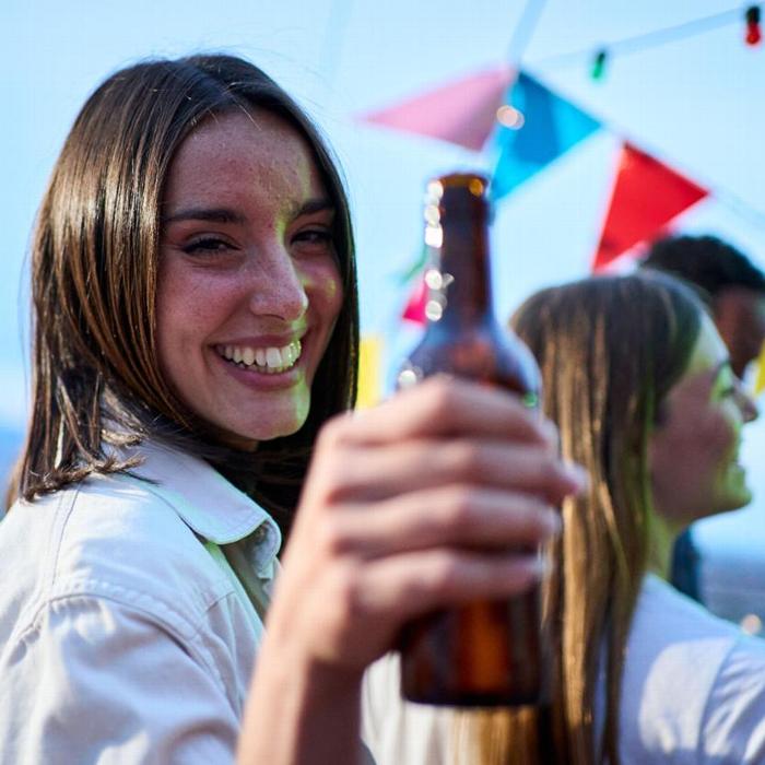 A woman holding a bottled beer